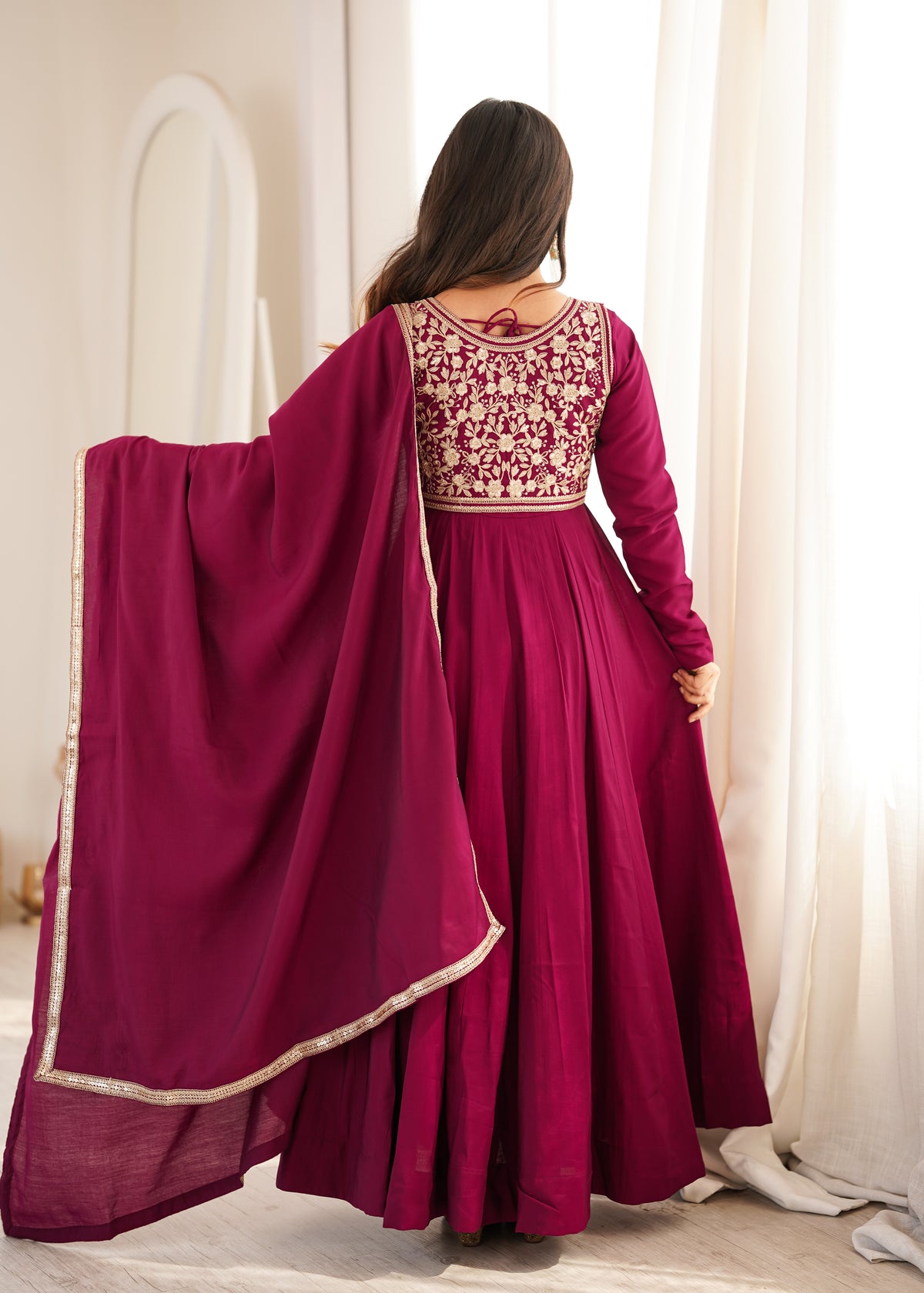 Rani pink Roman silk Anarkali gown featuring a flared silhouette and an intricately embroidered short jacket